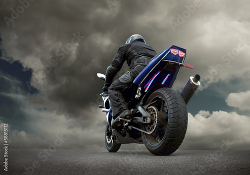 Obraz w ramie Man seat on the motorcycle under sky with clouds