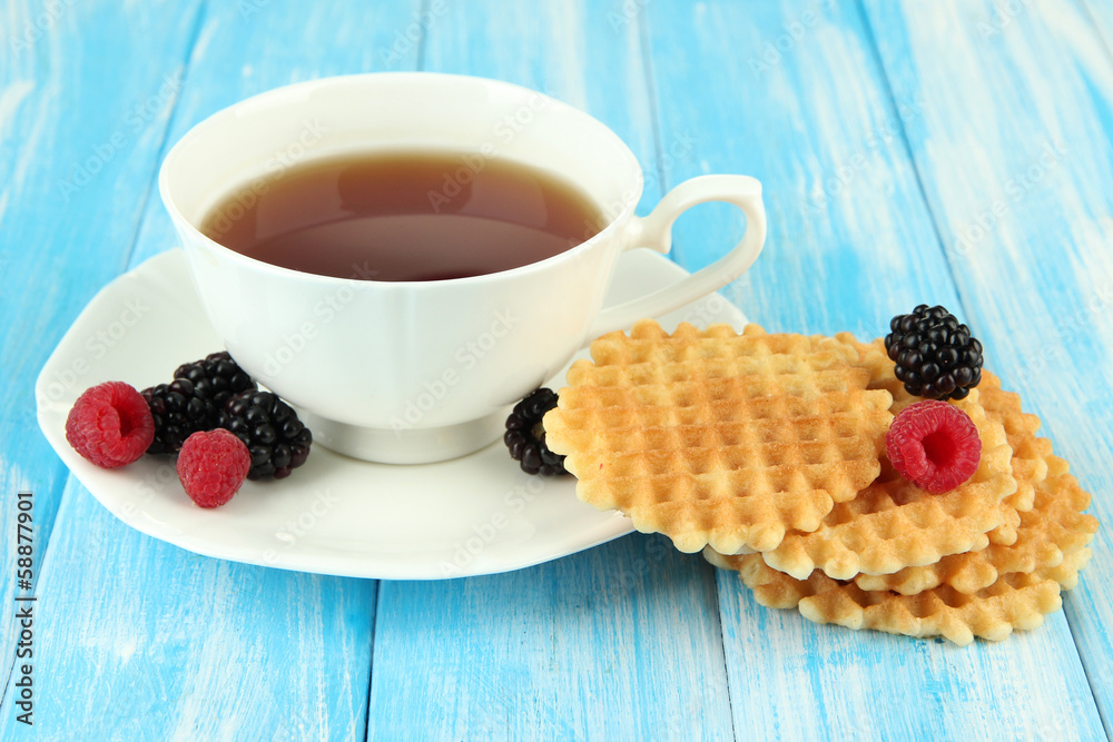 Cup of tea with cookies and berries on table close-up