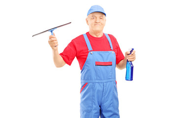 Wall Mural - Male cleaner in uniform holding a cleaning equipment for glass