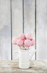 Poster - Pink cake pops on wooden table. Copy space