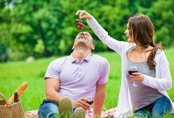 Fototapete - Woman hands grape and feeds man in park