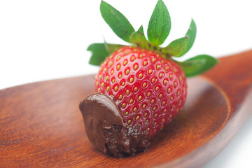 Wall Mural - Beautiful ripe strawberries in chocolate on a wooden spoon isola