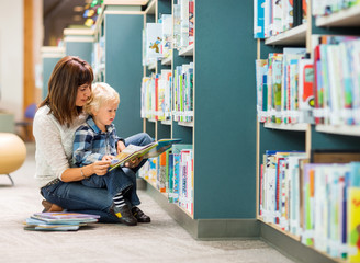 Student With Teacher Reading Book In Library