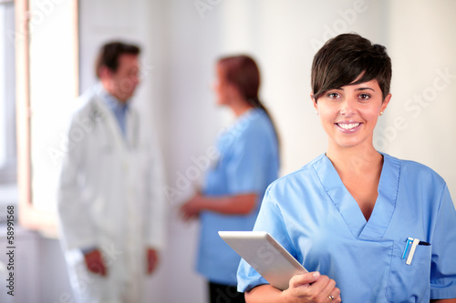 Fotografía La enfermera encantadora latino en azul uniforme de pie