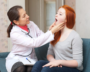 Wall Mural - doctor looks throat of teenager girl