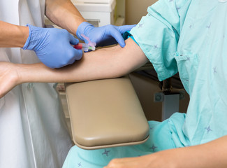 Wall Mural - Doctor Drawing Blood From Female Patient's Arm