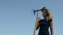 Beautiful Woman Play With Spin Windmill Pinwheel Toy On Blue Sky