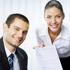 Two businesspeople with document at office