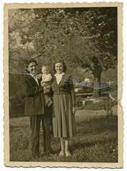 Wall Mural - Couple with their child between fruit trees - circa 1950