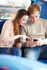 Wall Mural - Teenage Couple Reading Text Message On Bus