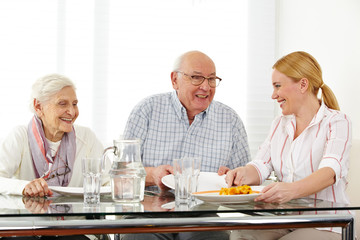 Family with senior couple eating lunch