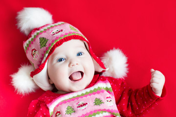 Wall Mural - Happy laughing baby girl in a red dress with Christmas ornament