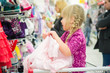 © Joshhh - Adorable girl on shoppping cart select pink dress in supermarket