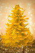 Dekoracja świąteczna - żółta choinka z piórek na tle lampek