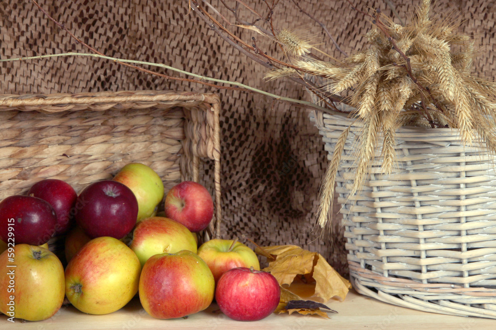 Ripe apples in basket on shelf on brown background