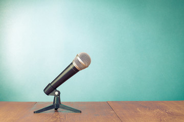 Poster - Classic microphone on table front aquamarine wall background