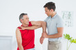 © lightwavemedia - Male physiotherapist stretching a mature mans arm