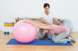© lightwavemedia - Physical therapist assisting senior woman with yoga ball