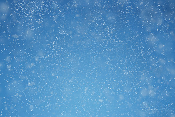 falling snow over blue background with copy space