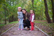 © travnikovstudio - Young mother with her little daughters looking to camera oudoor
