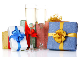 Glasses of champagne with gift boxes isolated on white