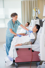 Nurse Covering Patient Undergoing Renal Dialysis With Blanket