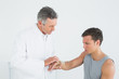 © lightwavemedia - Male doctor examining a patients hand