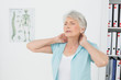 © lightwavemedia - Senior woman suffering from neck pain in medical office