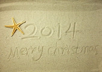 Wall Mural - Merry Christmas 2014 handwritten in sand on a beautiful beach