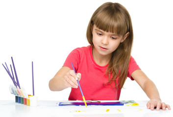 Fototapete - Little girl is painting with gouache