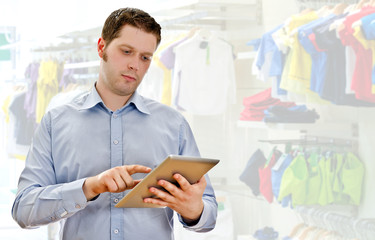 Supervisor with tablet pc in the clothing store