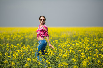 Wall Mural - Young beautiful woman in flowering field in summer. Outdoors