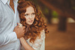 © GTeam - Portrait of young beautiful redhair woman standing in green park