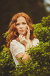 © GTeam - Portrait of young beautiful redhair woman standing in green park