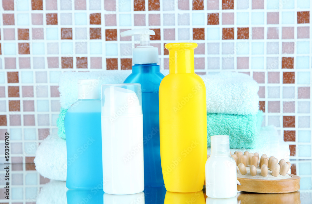 Cosmetics and bath accessories on mosaic tiles background