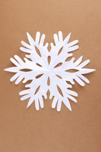 Beautiful Paper Snowflake On Brown Background