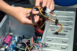 © shahrilkhmd - Closeup of a technician's hands wiring a computer mainboard
