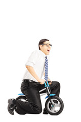 Wall Mural - Excited young businessperson riding a small bicycle