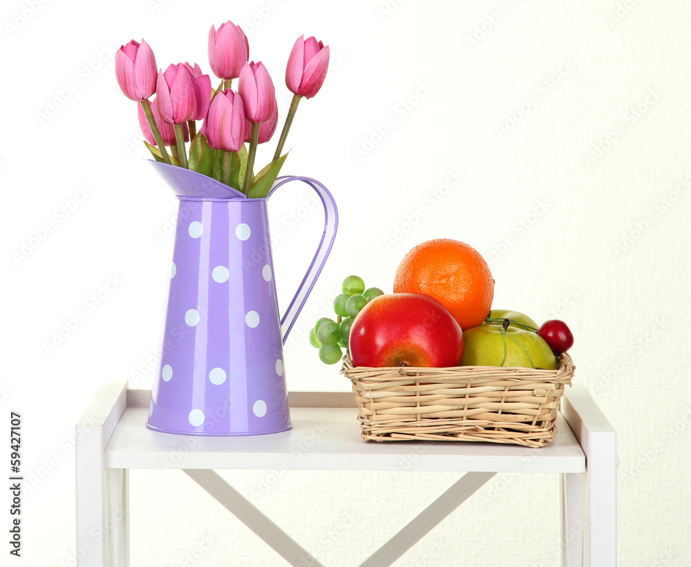 Flowers with fruit on white shelf on grey wall background