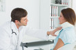 © lightwavemedia - Doctor examining a patient's neck in medical office