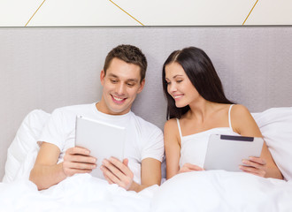 Sticker - smiling couple in bed with tablet pc computers