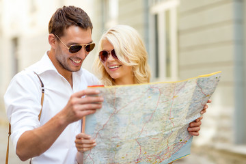 Poster - smiling couple in sunglasses with map in the city