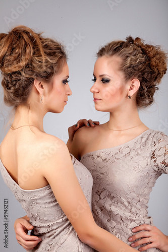 Fotografia, Obraz Two girls twins, isolated on the grey background