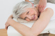 © lightwavemedia - Physiotherapist massaging a senior woman's shoulder