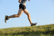 © Antonioguillem - Side view of a jogger legs running on the grass