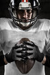 © guerrieroale - Portrait of american football player holding a ball and looking