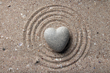 Wall Mural - Grey zen stone in shape of heart, on sand background