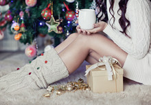 Young Pretty Woman Under New Year Tree With Christmas Cup Of Tea