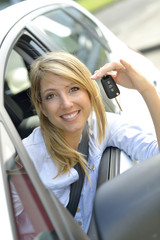 Cheerful young woman showing car key