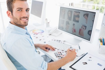 Wall Mural - Male photo editor working on computer in a bright office